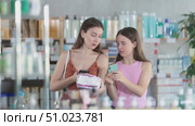 Woman and teen girl in pharmacy scans QR code feminine pads. Стоковое видео, видеограф Яков Филимонов / Фотобанк Лори