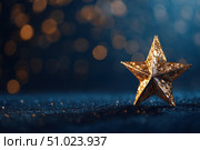Christmas Golden star, shiny shimmering against a dark blue background with bokeh lights. Abstract festive atmosphere for special events. Joyous vibe. Star-shaped gold decoration. Elegant night banner. Стоковое AI-изображение, AI-художник Марина Демидюк / Фотобанк Лори