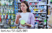 Portrait of smiling woman consumer choosing product at beauty shop, using smartphone for scanning barcode. Стоковое видео, видеограф Яков Филимонов / Фотобанк Лори