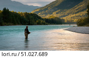 Fisherman fishing in river at sunset with mountain view. Стоковое AI-изображение, AI-художник Юрий Поздников / Фотобанк Лори