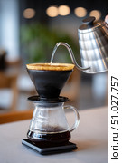 Barista pouring hot water into coffee dripper. Стоковое AI-изображение, AI-художник Юрий Поздников / Фотобанк Лори