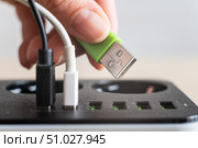 Modern convenient multi-port usb charger for devices. Close-up of a female hand plugging multi-colored cables into a power outlet. Macro. Стоковое фото, фотограф Михаил Решетников / Фотобанк Лори