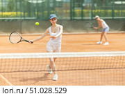 Woman playing tennis against female opponent on tennis court. Стоковое фото, фотограф Яков Филимонов / Фотобанк Лори