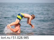 A man throws up a boy who dives into the sea on a sunny summer day. Стоковое фото, фотограф Лазаренко Светлана / Фотобанк Лори