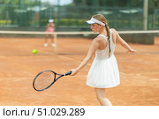 Woman playing tennis against female opponent on tennis court. Стоковое фото, фотограф Яков Филимонов / Фотобанк Лори