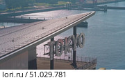 Tokyo, Japan - Oct 13 2024, 4k panoramic view of docks with cranes and containers, in foreground is signage with word Tokyo on roof of Tokyo cruise port, view from deck of MSC Bellissima, Tokyo, Japan. Редакционное видео, видеограф Сергей Богомяко / Фотобанк Лори