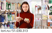 Young woman choosing a set of plastic and wooden clothespins for laundry in a household store. Стоковое видео, видеограф Яков Филимонов / Фотобанк Лори