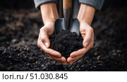 Black recycled compost on shovel on agricultural field background, sustainable farming and gardening concept with earthworms. waste recycling, waste-free production, preservation of the Earth's ecology. Стоковое AI-изображение, AI-художник ALLA YURTAYEVA / Фотобанк Лори