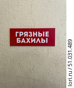 Красная табличка на стене с белой надписью "Грязные бахилы". Вывеска в медицинском учреждении, поликлинике или больнице. Стоковое фото, фотограф Евгений Ковальский / Фотобанк Лори