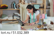 Woman tailor uses tablet when creating drawing of future product. Стоковое видео, видеограф Яков Филимонов / Фотобанк Лори