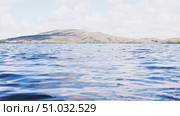 Lake Bannoe, Russian Federation - July 31, 2025: Serene lake view with gentle ripples reflecting clouds and distant hills under a bright blue sky, showcasing natural beauty and tranquility. Редакционное видео, видеограф Ирина Ручушкина / Фотобанк Лори