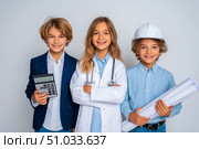 Three children dressed as professionals, one with a calculator, another in a hard hat and goggles, and the last holding blueprints, showcasing future career aspirations and teamwork. Стоковое AI-изображение, AI-художник Ирина Ручушкина / Фотобанк Лори