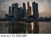 Moscow, Russia - July 18, 2025: Evening view of the Moscow International Business Center skyscrapers and reflections shimmering on the Moscow River. Редакционное фото, фотограф Софья Соломонова / Фотобанк Лори
