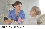 Old woman patient lying on clinical chair discussing face aesthetic procedures with doctor. Стоковое видео, видеограф Яков Филимонов / Фотобанк Лори