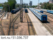 Railway station yard with blue carriages on parallel tracks, semaphore signal, concrete platforms, overhead line supports, turnout switches. Passenger service layover, marshalling activities. Стоковое фото, фотограф Андрей Ка / Фотобанк Лори