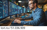 A programmer is deeply engaged, coding and analyzing data on several screens in a contemporary workspace after hours. Стоковое AI-видео, аниматор Данила Большаков / Фотобанк Лори