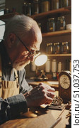 A Skilled Artisan Concentrates on Crafting Intricate Clock Mechanisms in a Warm Workshop, Embodying the Timeless Art of Watchmaking and Precision Engineering. Стоковое AI-видео, аниматор Владимир Федоров / Фотобанк Лори