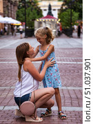 Heartwarming Embrace Between Mother and Daughter on a Cobblestone Square in Europe. Стоковое фото, фотограф Aleksandr Golubev / Фотобанк Лори