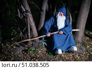 A wizard with a long gray beard and a cloak in a deep forest. An elderly man in a witcher costume. Стоковое фото, фотограф Михаил Решетников / Фотобанк Лори