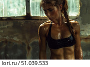Sweaty female athlete resting after intense workout in urban gym. Стоковое AI-изображение, AI-художник Иван Рябоконь / Фотобанк Лори