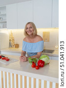 Healthy Cooking in a Modern Kitchen A Woman Skillfully Preparing Fresh, Colorful Vegetables with Care. Стоковое фото, фотограф Anastasy Yarmolovich / Фотобанк Лори