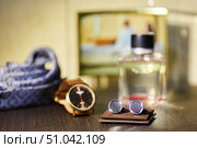 Men's cufflinks in the foreground. In the background is a tie, perfume and a watch. A favorite focus, a place for text. A set of accessories for a wedding. Стоковое фото, фотограф Наталия Кирсанова / Фотобанк Лори
