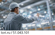 Worker observes operations in modern warehouse environment with advanced technology and bright lighting. Стоковое AI-видео, аниматор Сергей Толмачёв / Фотобанк Лори