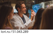 Scientist presenting engaging information at an interactive exhibit in a modern science center. Стоковое AI-видео, аниматор Сергей Толмачёв / Фотобанк Лори