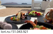 Grilled salmon steak with crispy skin sauteed vegetables and lemon served in outdoor restaurant in summer light A wooden table with a variety of dishes containing seafood, vegetables and fruit.Hand holding a spoon ready to eat pineapple fried rice with shrimp, served in a pineapple bowl, surrounded by fresh fruits and tea on a cozy table setting.Party Sea Food platter with salmon and prawns, low angle view, close-up Sea food party platter, extreme Whole poached salmon with cucumber slices for scales, high end party platter, overhead view Tiger prawns on the grill Macarooni cookies floating on blue background, levitation, macarooni cookies, dessert, sweets, colorful, delicious Two Glasses of Pink Champagne with Macarons and Oranges Elegant seaside celebration with seafood, pink floral decor, and sparkling wine overlooking the ocean. Стоковое видео, видеограф Zita Khasanova / Фотобанк Лори