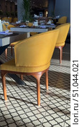 Luxury Arabian resort Empty tables and chairs along white buildings Round tables and chairs at an open-air restaurant An empty cafe, restaurant terrace in an urban environment amide's lush vegetation greenery. Seating, vintage tables and chairs served for guests. Luxurious reception table Tableware on tablecloths.Interior of restaurant with orange chairs, tables, brick walls. Empty eatery features bar counter, loft design, modern lighting, large windows. Cafe is ready to serve food, beverages for clients. Стоковое видео, видеограф Zita Khasanova / Фотобанк Лори