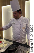 Hotel chef preparing omelet Breakfast Buffet Chafing Dishes With Bacon And Eggs The chef fries an egg in a frying pan. Adding salt to the eggs by the chef hands. Healthy breakfast from scrambled eggs. Редакционное видео, видеограф Zita Khasanova / Фотобанк Лори
