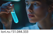 Scientist examines glowing liquid in test tube during laboratory experiment at night. Стоковое AI-видео, аниматор Сергей Толмачёв / Фотобанк Лори