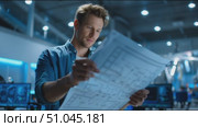 Engineer examines blueprints in a modern workspace with advanced technology. Стоковое AI-видео, аниматор Сергей Толмачёв / Фотобанк Лори