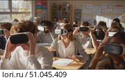Students engage in virtual reality learning in classroom setting during afternoon session. Стоковое AI-видео, аниматор Сергей Толмачёв / Фотобанк Лори