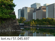 Skyscrapers of the Marunouchi business district in Chiyoda Ward against the background of the Hamaguri-moat and the ramparts of the Imperial Palace on a sunny day, Tokyo, Japan. Стоковое фото, фотограф Ula Ulachka / Фотобанк Лори