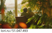 Two individuals are quietly seated on a bench, gazing out of a window. They are engaged in observation and contemplation. Стоковое AI-видео, аниматор Данила Большаков / Фотобанк Лори