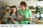 Family chooses sweets cookies and nougat - in the grocery section of a supermarket. Стоковое видео, видеограф Яков Филимонов / Фотобанк Лори