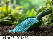 Green scoop with fertilizer blue granules. Granular chemical fertiliser for plant over soil background. Role of nutrients mineral in plants growth, soil life. Space for text. Gardening time. Planting. Стоковое AI-изображение, AI-художник Марина Демидюк / Фотобанк Лори