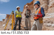 Geological survey team analyzing rock formation in desert environment. Стоковое AI-видео, аниматор Юрий Поздников / Фотобанк Лори