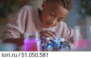 Young boy explores robotics and science with colorful liquids and gadgets during an afternoon activity at home. Стоковое AI-видео, аниматор Сергей Толмачёв / Фотобанк Лори
