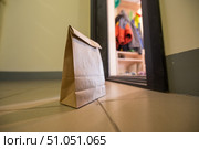 An eco paper bag is standing in the lobby on the doorstep of the apartment. Contactless food delivery to the epidemic. The courier left an online order at the entrance. precautionary measures. Стоковое фото, фотограф Михаил Решетников / Фотобанк Лори