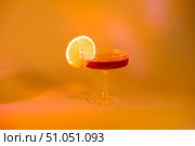 Glass of champagne with a slice of orange on an orange background, with shadows. Стоковое фото, фотограф Кашапова Эльвира / Фотобанк Лори