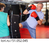 Elderly man practices kicking and punching with a trainer in gym. Стоковое фото, фотограф Яков Филимонов / Фотобанк Лори