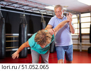 Elderly man learning self-defense grips and escapes at gym. Стоковое фото, фотограф Яков Филимонов / Фотобанк Лори