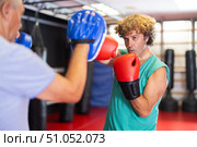 Middle‑aged man practicing punches on mitts with partner. Стоковое фото, фотограф Яков Филимонов / Фотобанк Лори