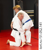 Senior aikido practitioner training with partner in dojo. Стоковое фото, фотограф Яков Филимонов / Фотобанк Лори