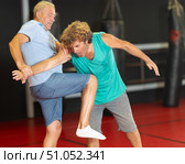 Male pupil clash with training manager during self-defense lesson, repulse charge, intensity of practice. Стоковое фото, фотограф Яков Филимонов / Фотобанк Лори