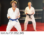 Middle‑aged karateka practicing punches in dojo. Стоковое фото, фотограф Яков Филимонов / Фотобанк Лори