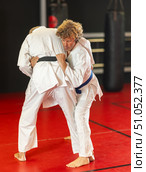 Jiu‑jitsu fighter practicing techniques on red tatami. Стоковое фото, фотограф Яков Филимонов / Фотобанк Лори