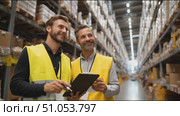 Workers collaborate in a warehouse discussing inventory management strategies and using a tablet for updates. Стоковое AI-видео, аниматор Сергей Толмачёв / Фотобанк Лори